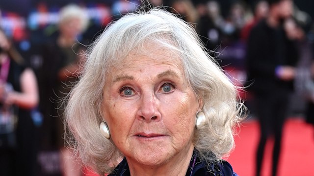 woman on red carpet in purple outfit 