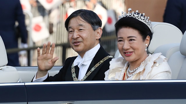 Emperor Naruhito and Empress Masako waving from a car