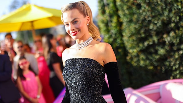 Margot Robbie dressed as 1960s Barbie at Los Angeles premiere surrounded by fans