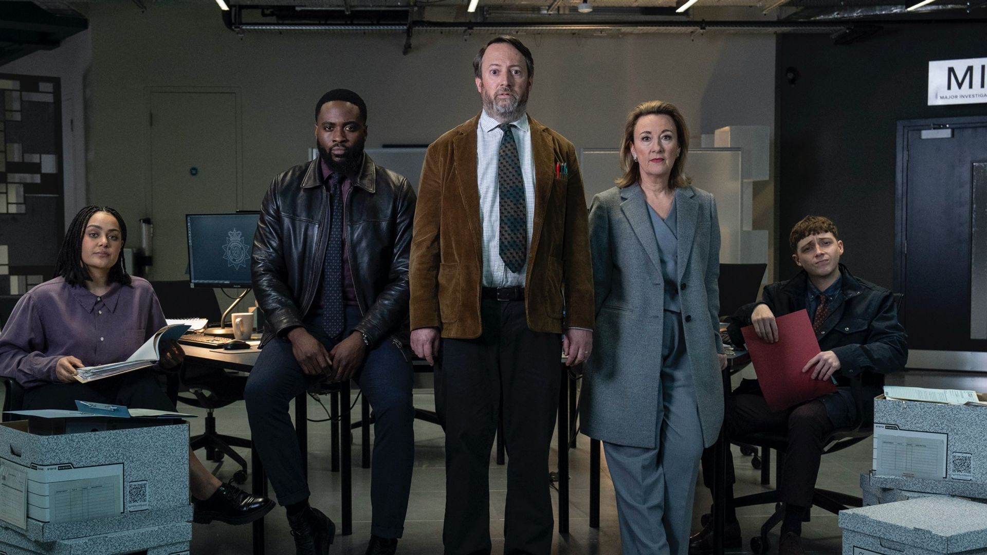 group of detectives standing in warehouse