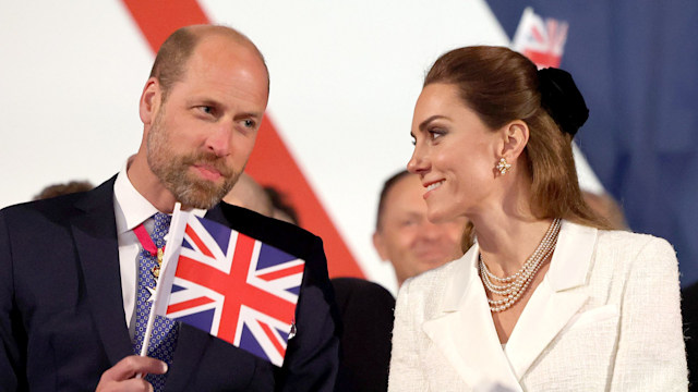 William and Kate smiling at each other and waving flags