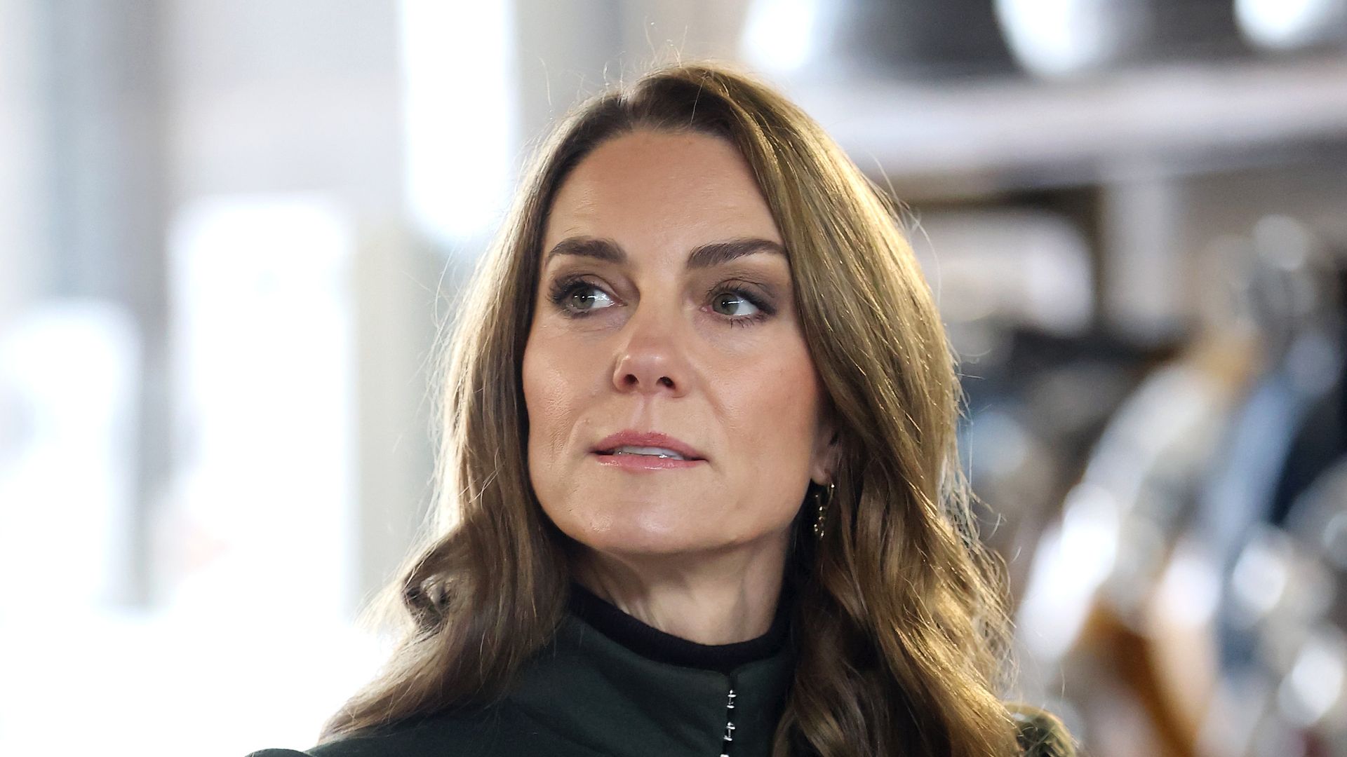 Catherine, Princess of Wales in green coat dress looking to left