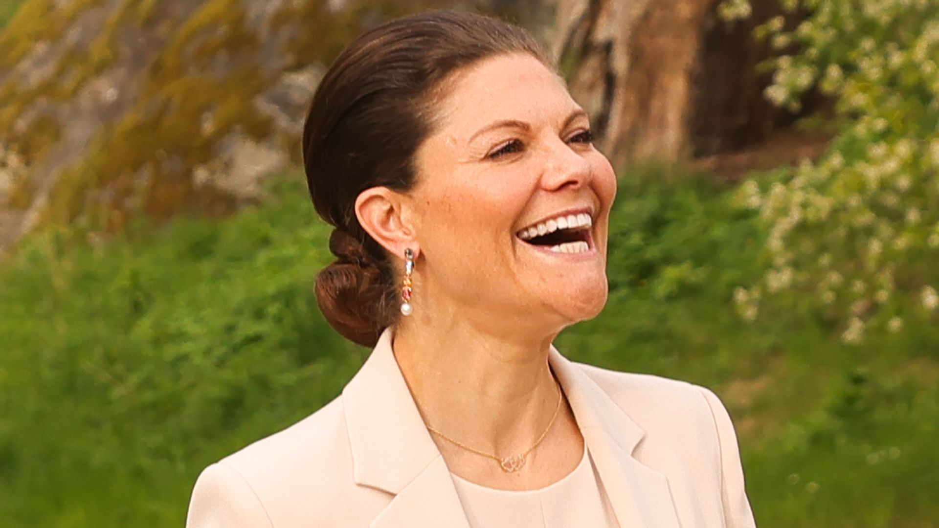 Crown Princess Victoria of Sweden laughing with her hair in a bun