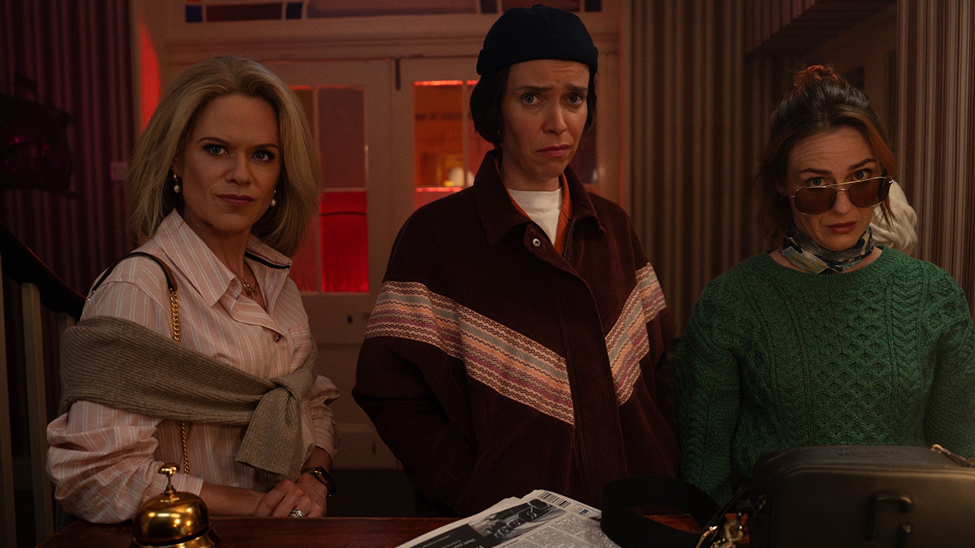 three women standing at reception desk 