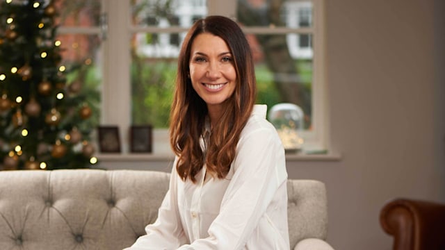 Woman sitting on a sofa in a white shirt and blue jeans 