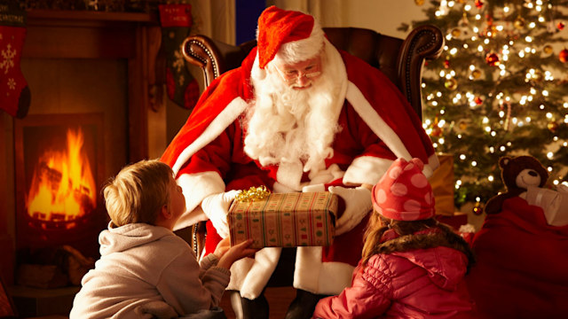 Father Christmas giving gift to children in grotto