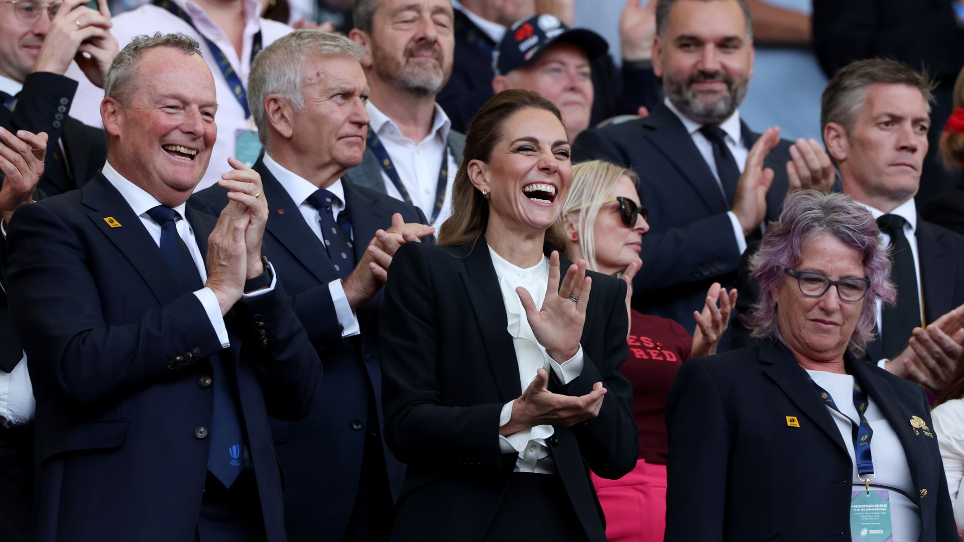 Kate Middleton laughing and applauding in a crowd