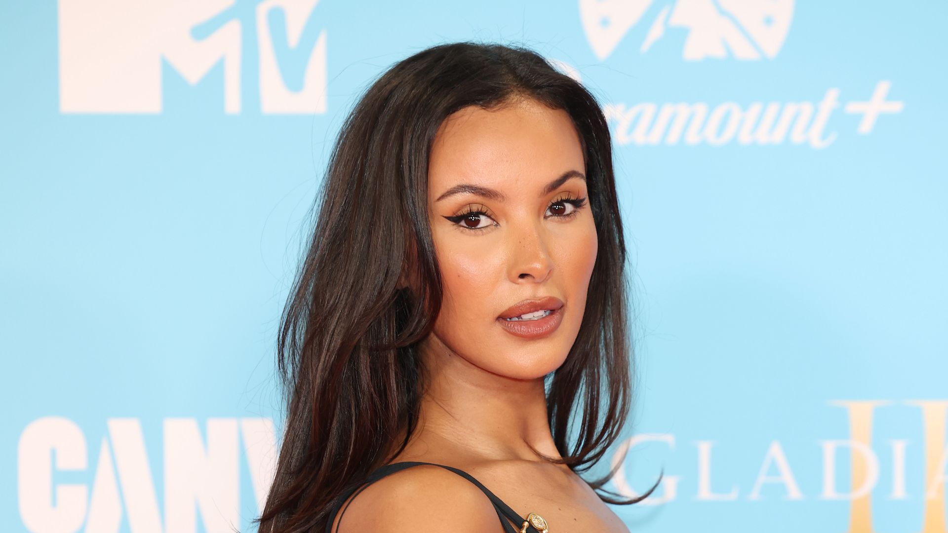 Maya Jama cosplays Elizabeth Hurley in plunging thigh-high slitted safety pin dress