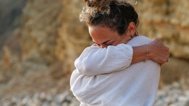 Young woman practices yoga on sandy beach