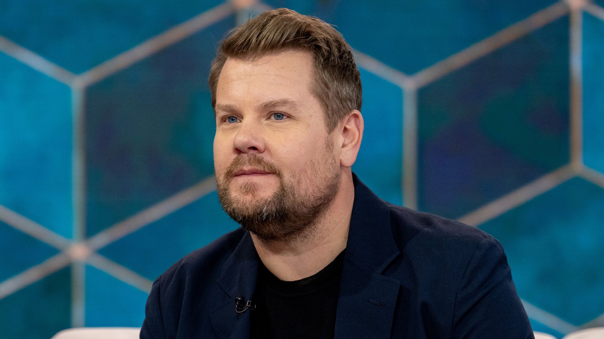 James Corden sitting on a cream sofa looking at camera while filming TODAY on NBC