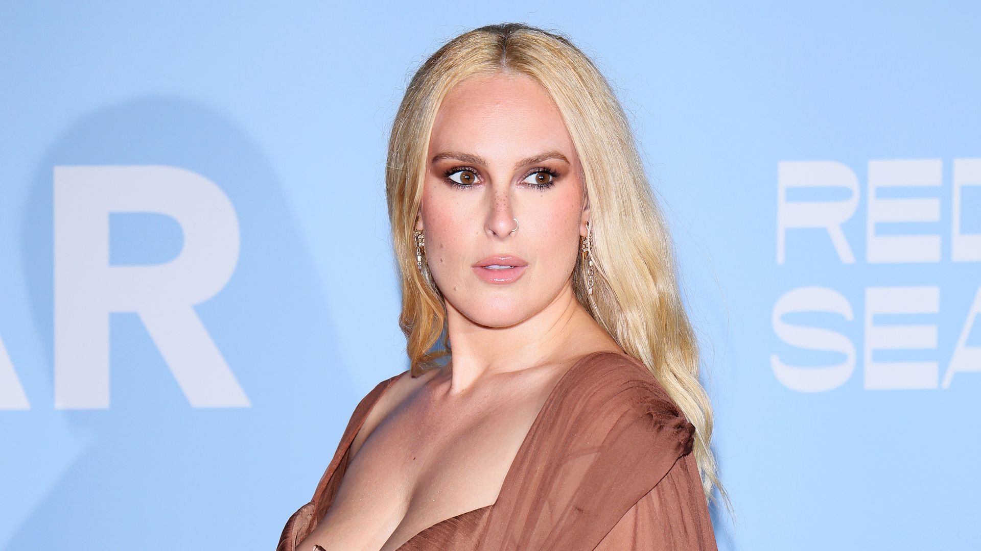 Rumer Willis posing in a brown dress