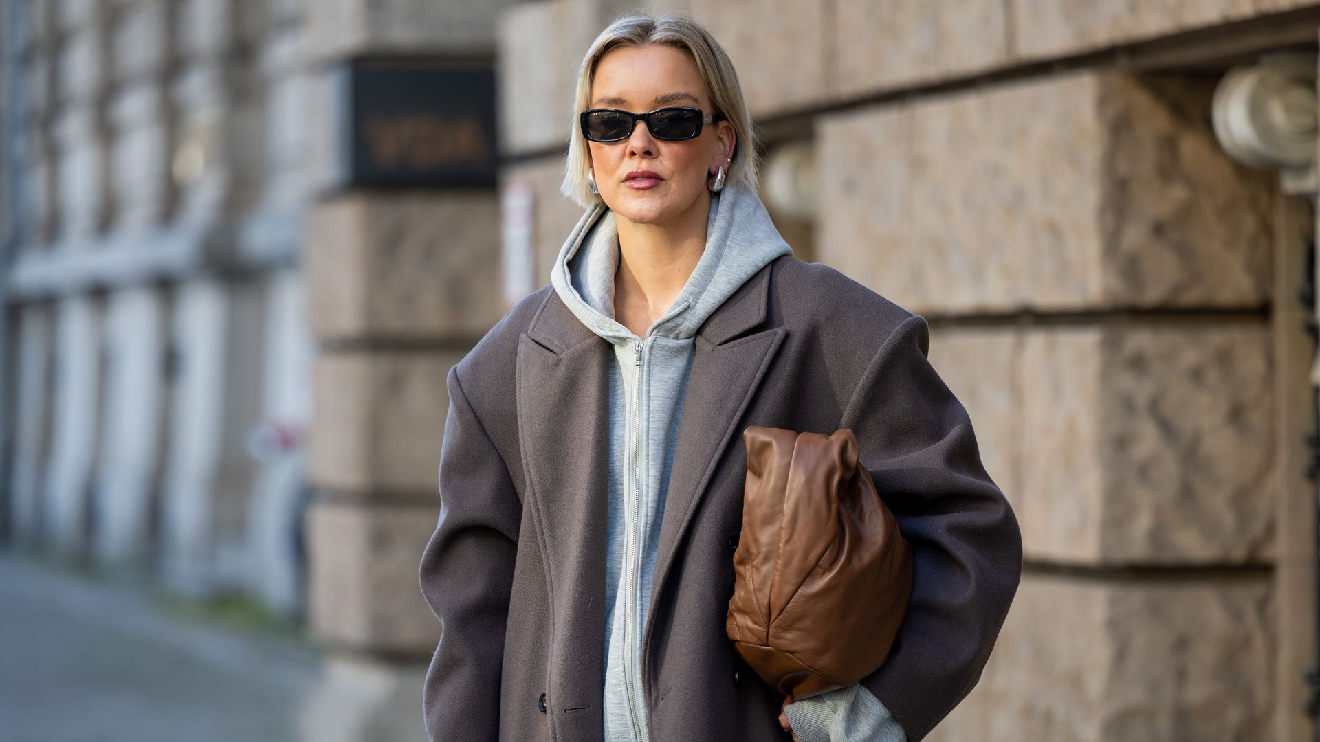 Tina Haase wears Sourceunknown taupe oversize coat, Beaumont grey zipper hoodie , Superdry baggy jeans, Borbonese brown maxi bag, Mango slingback heels