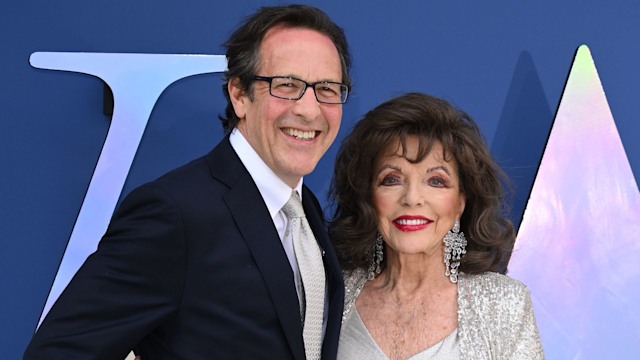 Percy Gibson wearing a black suit with Joan Collins in a silver dress