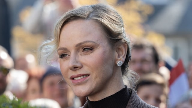 princess charlene smiling in check suit 