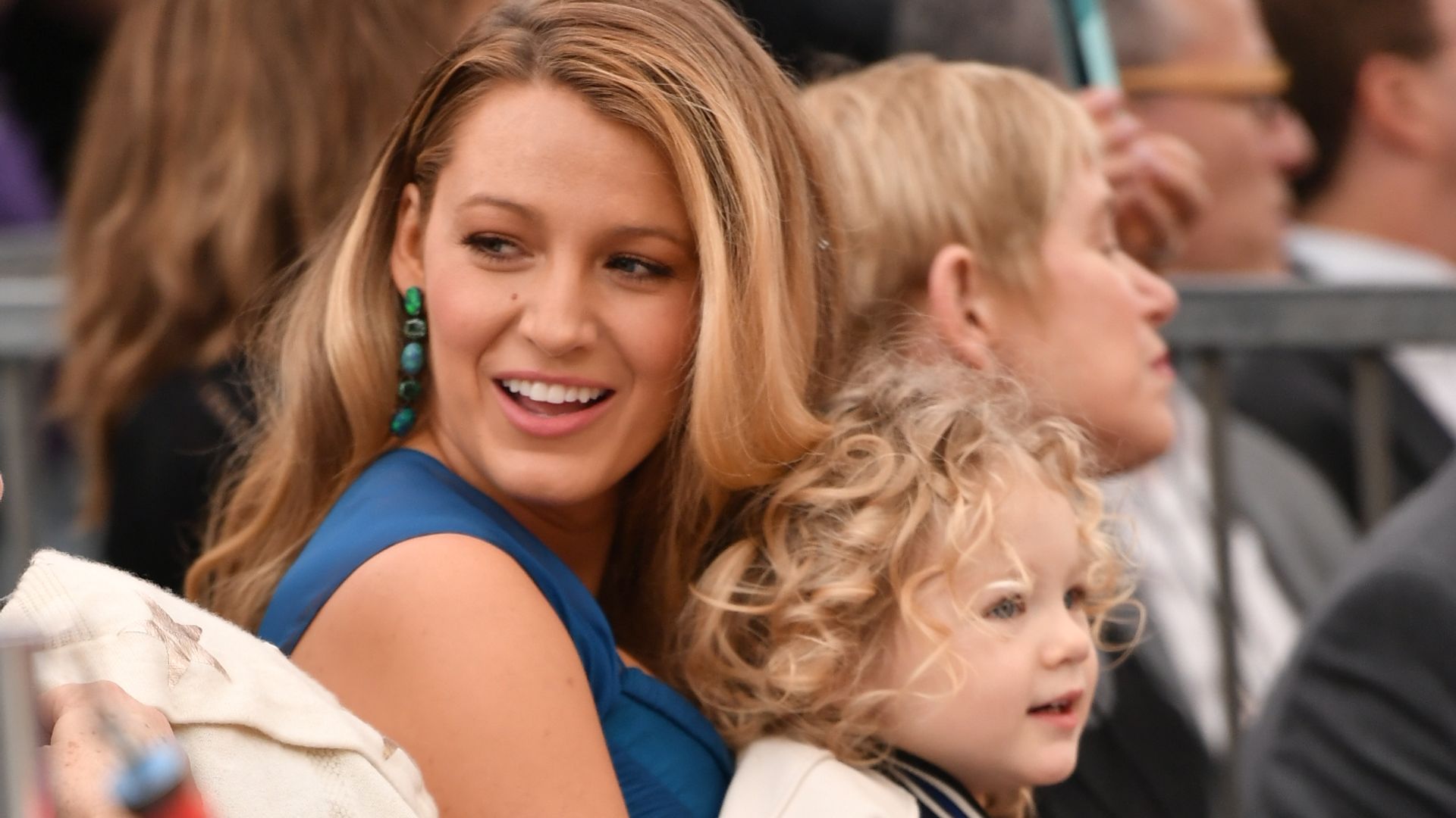 Blake Lively in blue dress holding daughterJames Reynolds