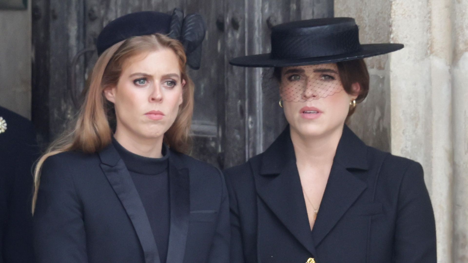 Princess Beatrice and Princess Eugenie looking sad in black outfits