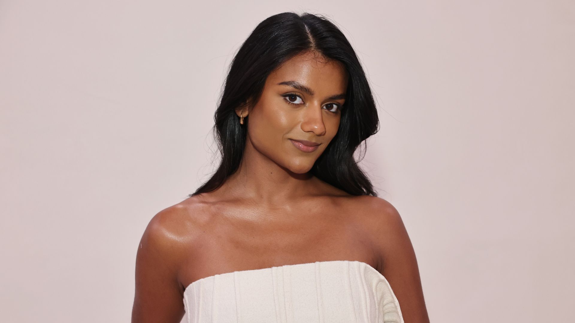 Simone Ashley attends the Calvin Klein Collection fashion show during February 2025 New York Fashion Week in a strapless white dress