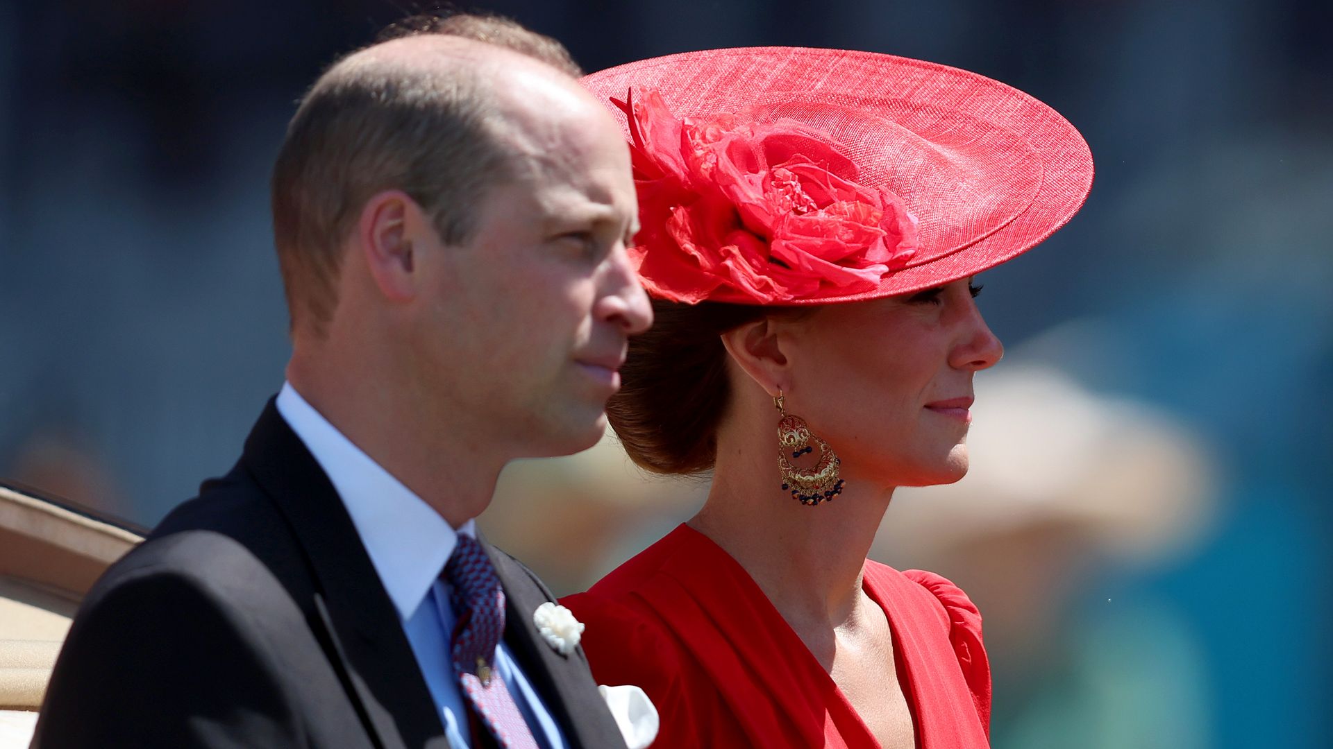 Prince William and Kate Middleton looking stoic in a carriage