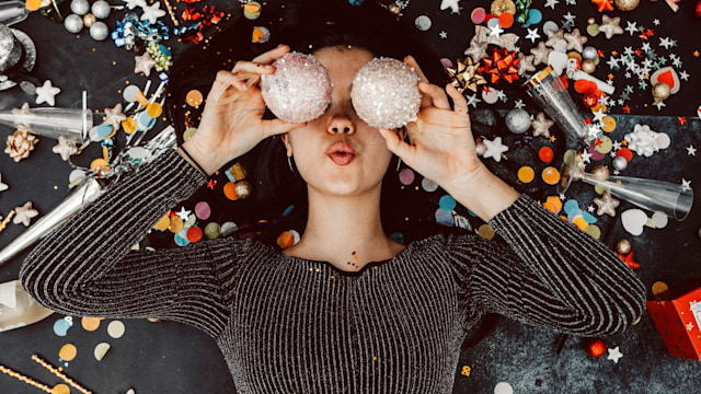 Woman lying on her back surrounded by Christmas decorations