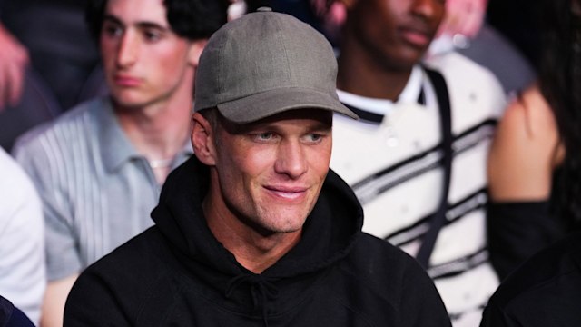 Tom Brady in black hoodie and cap