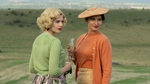 Two women in period clothing standing in field