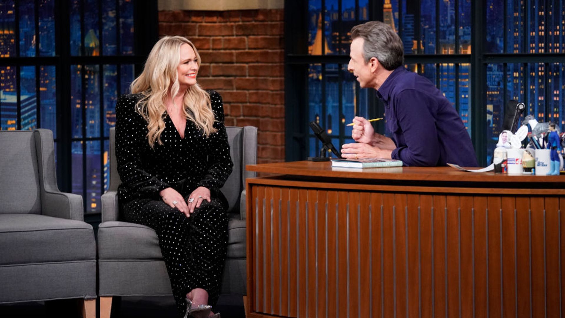 Miranda on Late Night with Seth Meyers. She is wearing a black suit embellished with diamantes