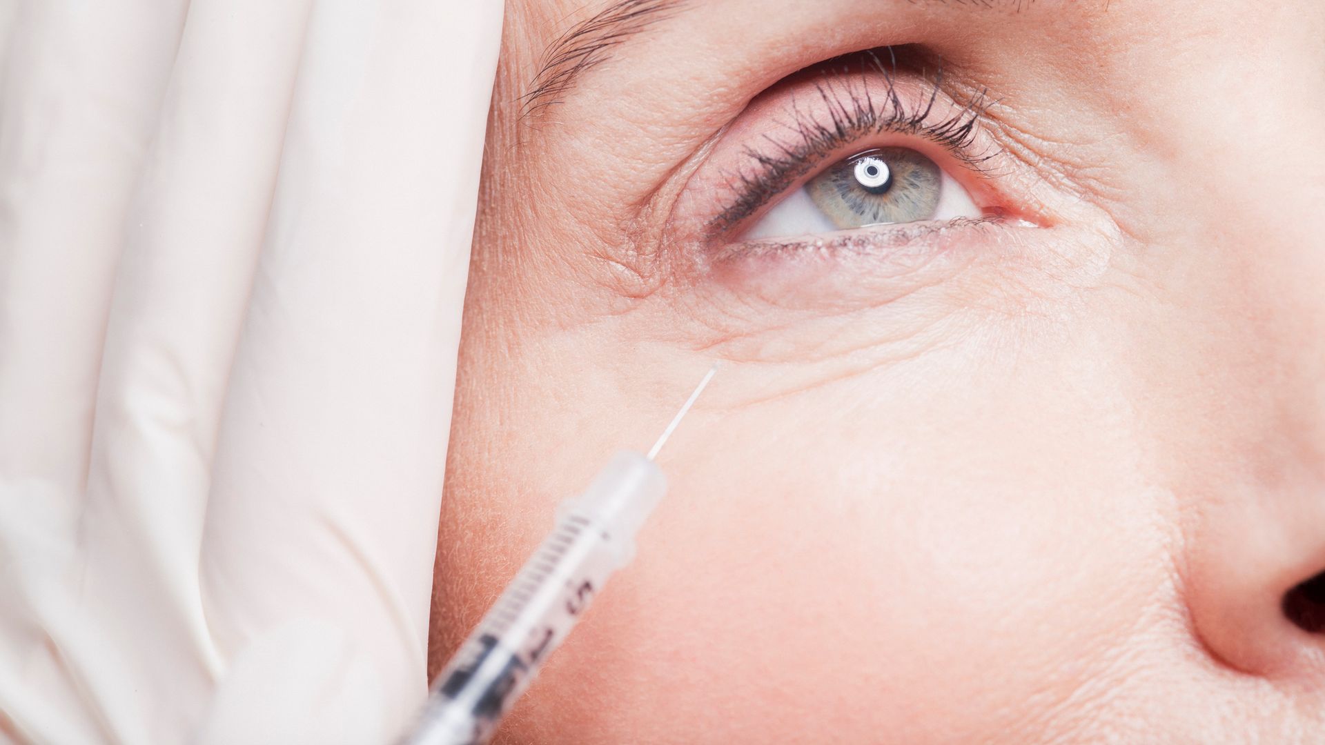Close up of woman receiving botox injection under eye
