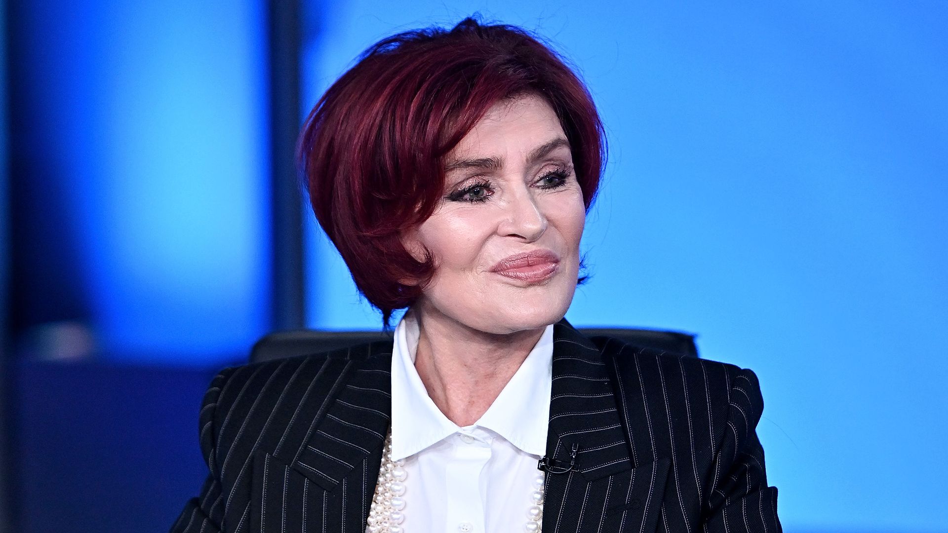 Sharon Osbourne in a pin strip suit on TV