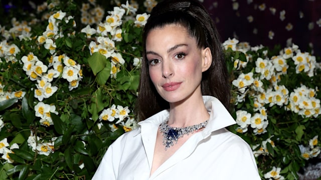 anne hathaway in white shirt and striped shirt at 2025 met gala