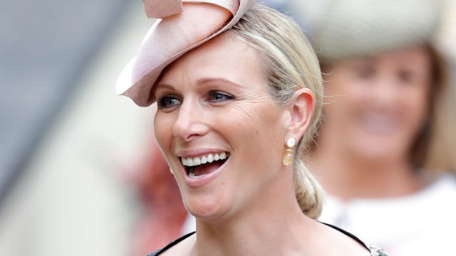 Zara Tindall smiling in black floral dress and pink hat