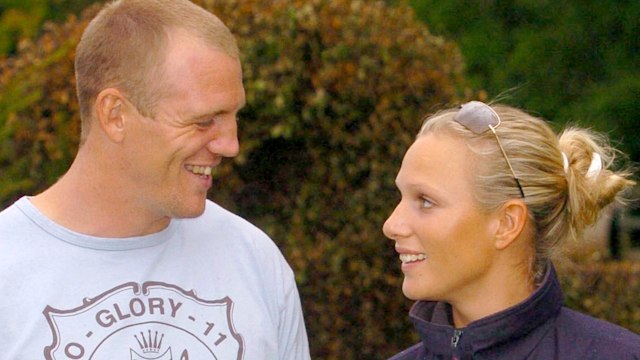 Mike Tindall in a blue T-shirt looking at Zara Phillips in a waterproof jacket