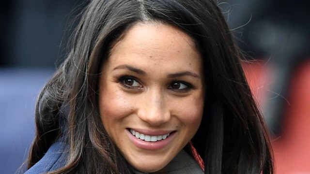 meghan markle smiling in blue coat 