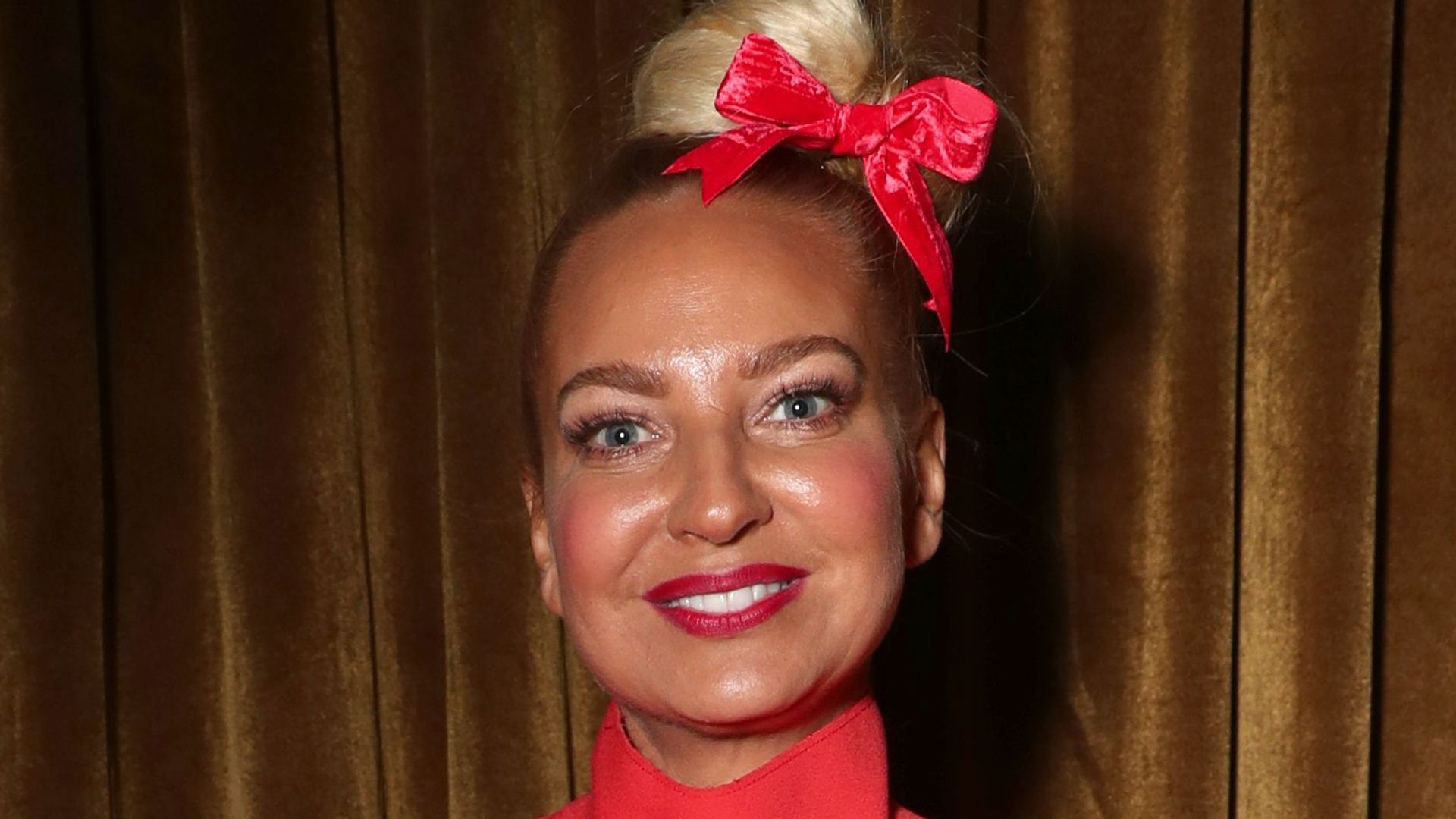 Sia wearing a red dress and a hair bow