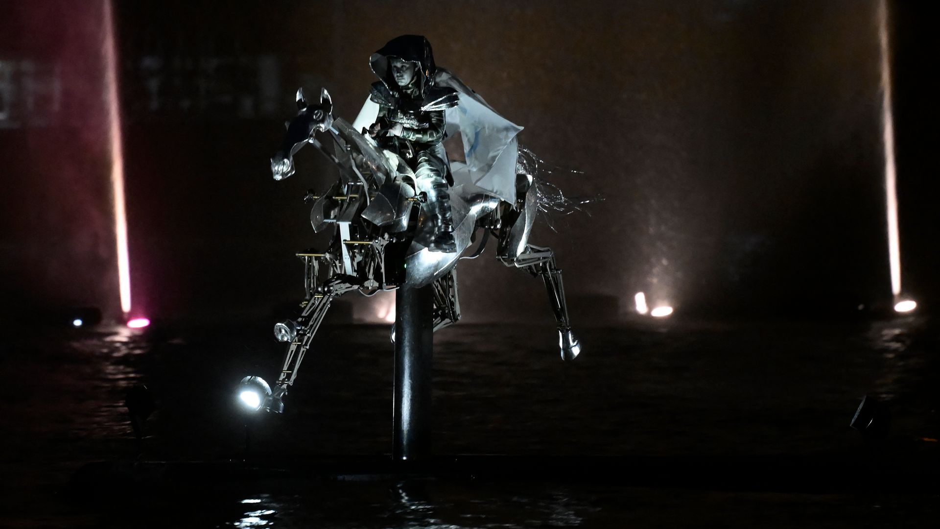 Floriane Issert, a Gendarmerie non-commissioned officer of the National Gendarmerie, rides on a mechanical metal horse up the Seine river, wrapped in the Olympic flag during the opening ceremony of the Paris 2024 Olympic Games 