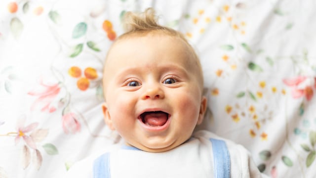 Baby laughing on bed