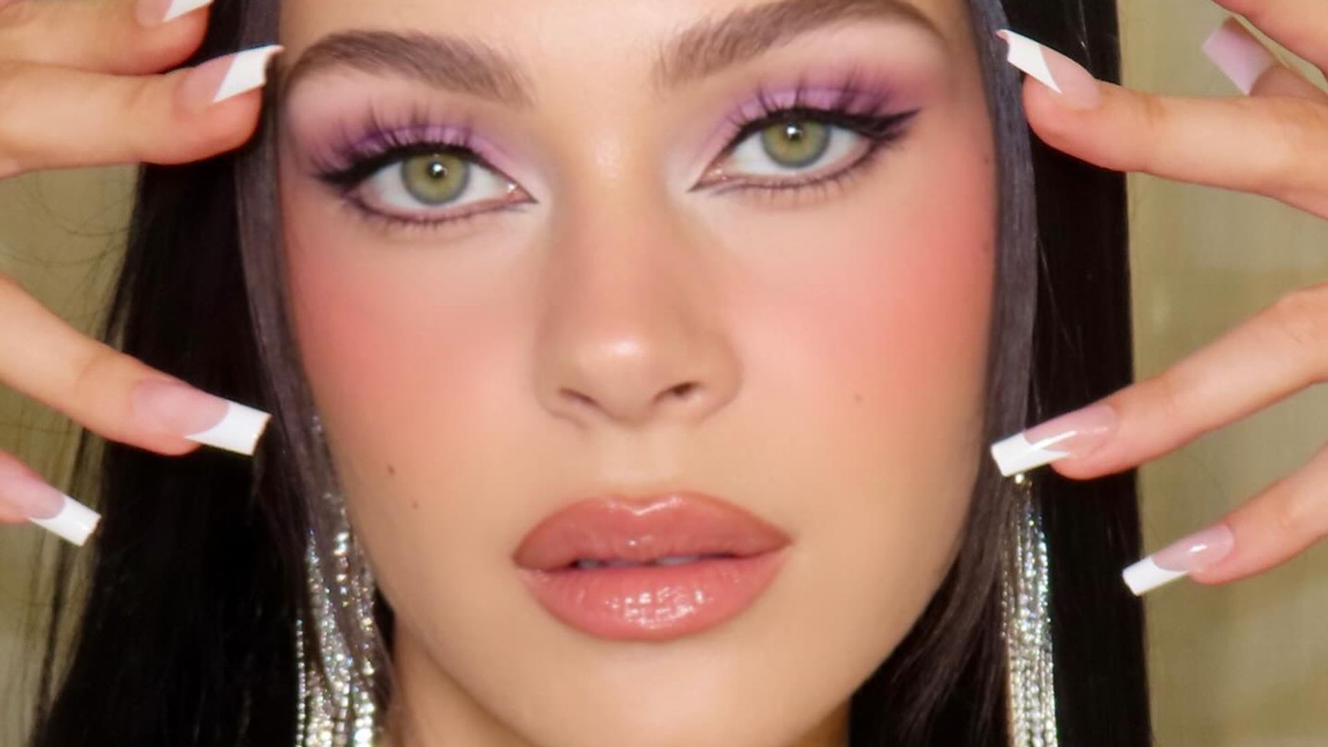 Nicola Peltz Beckham poses for a photo wearing lilac eyeshadow 