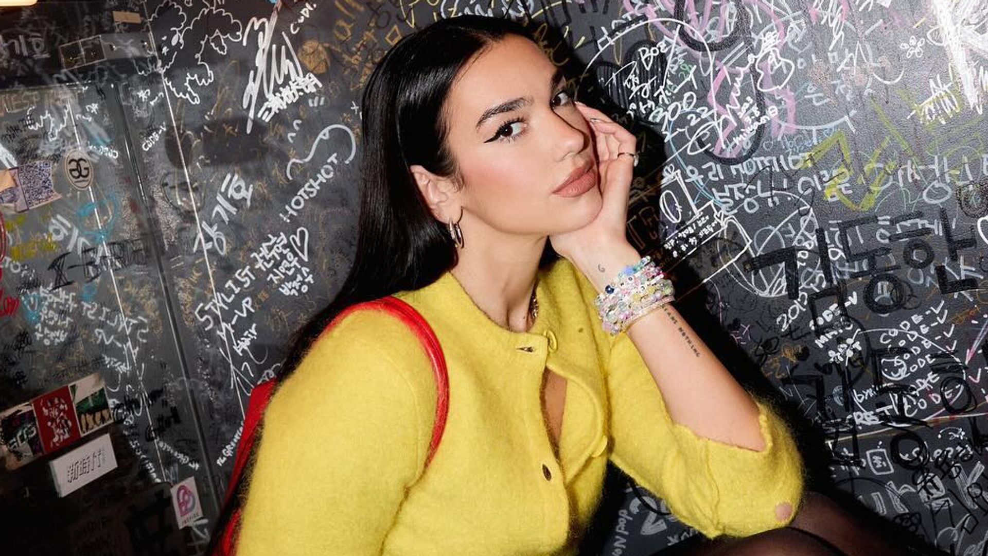 Dua Lipa’s cheeky leather hotpants, sheer tights and lemon-yellow cardigan combo is a thing of dreams