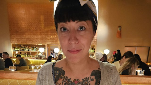 Woman with a dark fringe wearing a denim dress