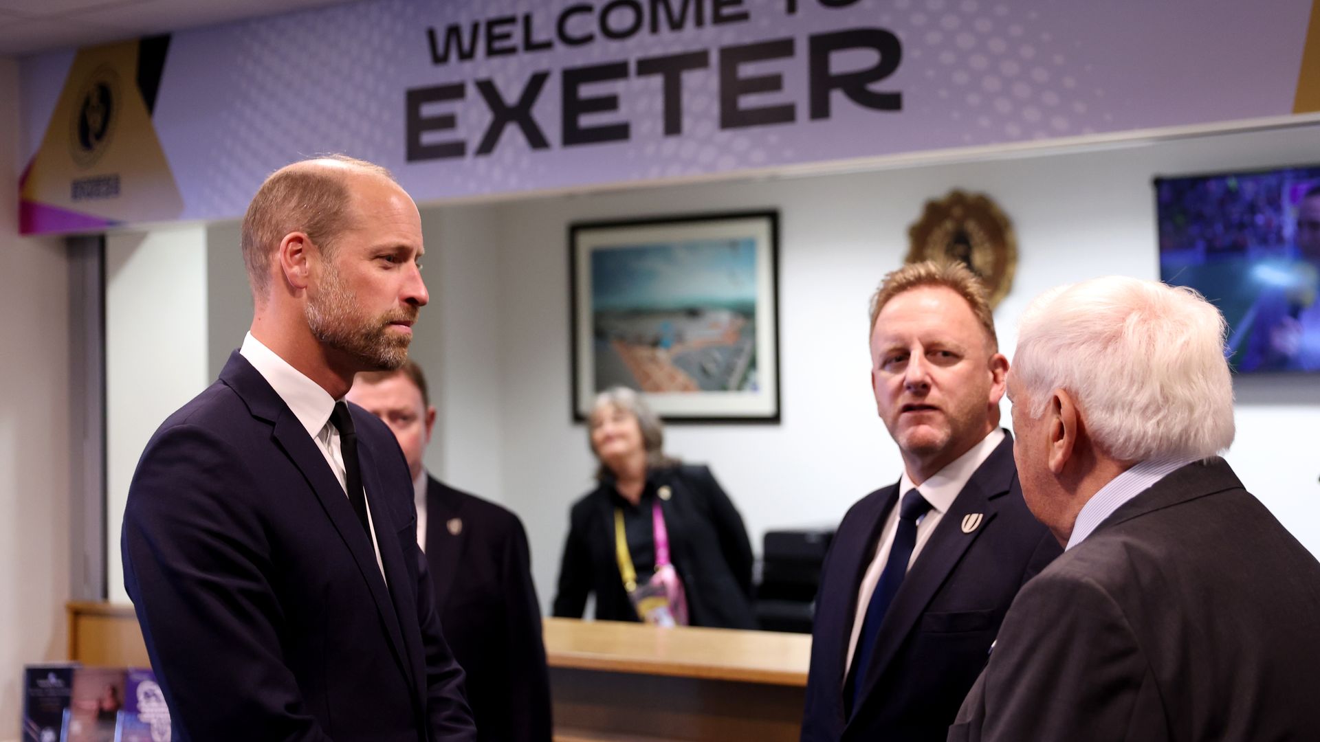 Prince William talking to a group of men