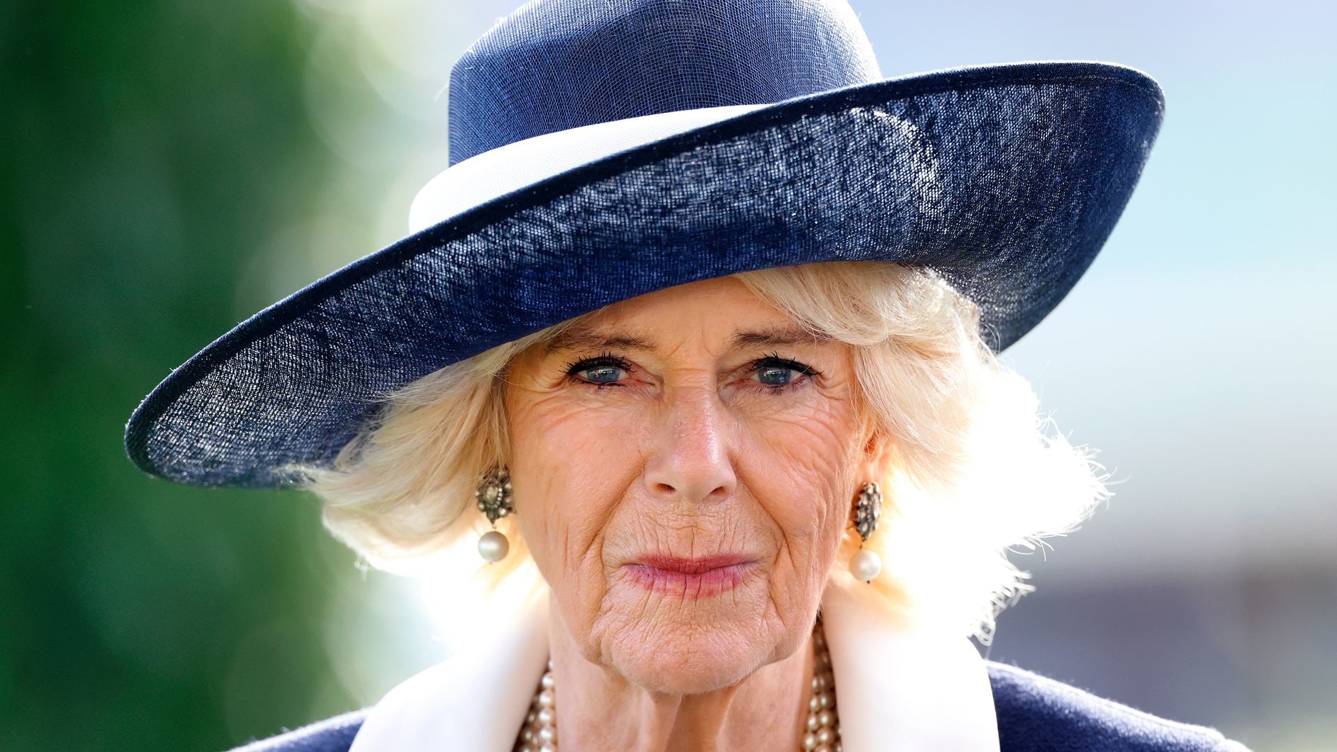 Queen Camilla in navy and white dress and pearls