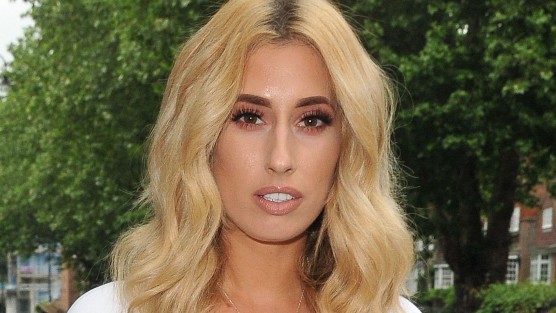 Stacey Solomon with a straight face in a white dress