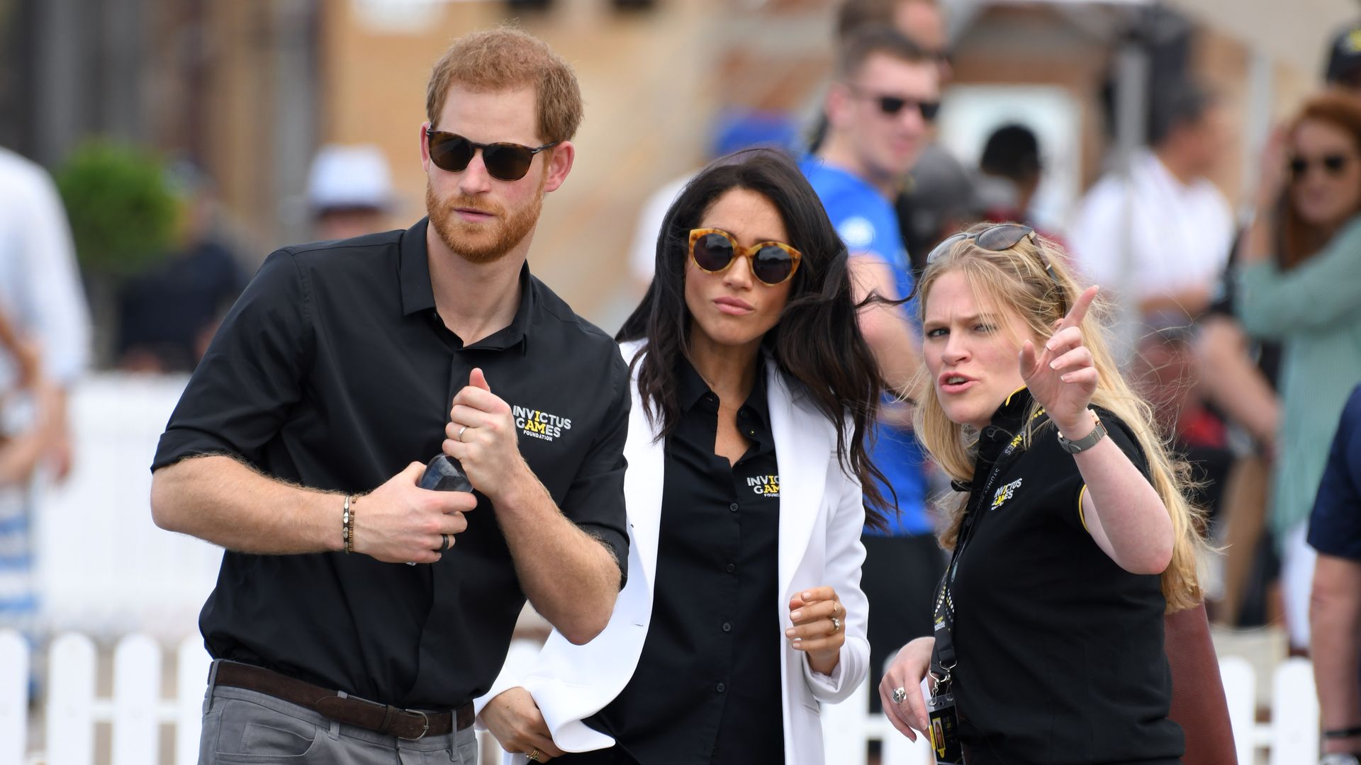 Prince Harry and Meghan Markle speaking to an aide in Australia