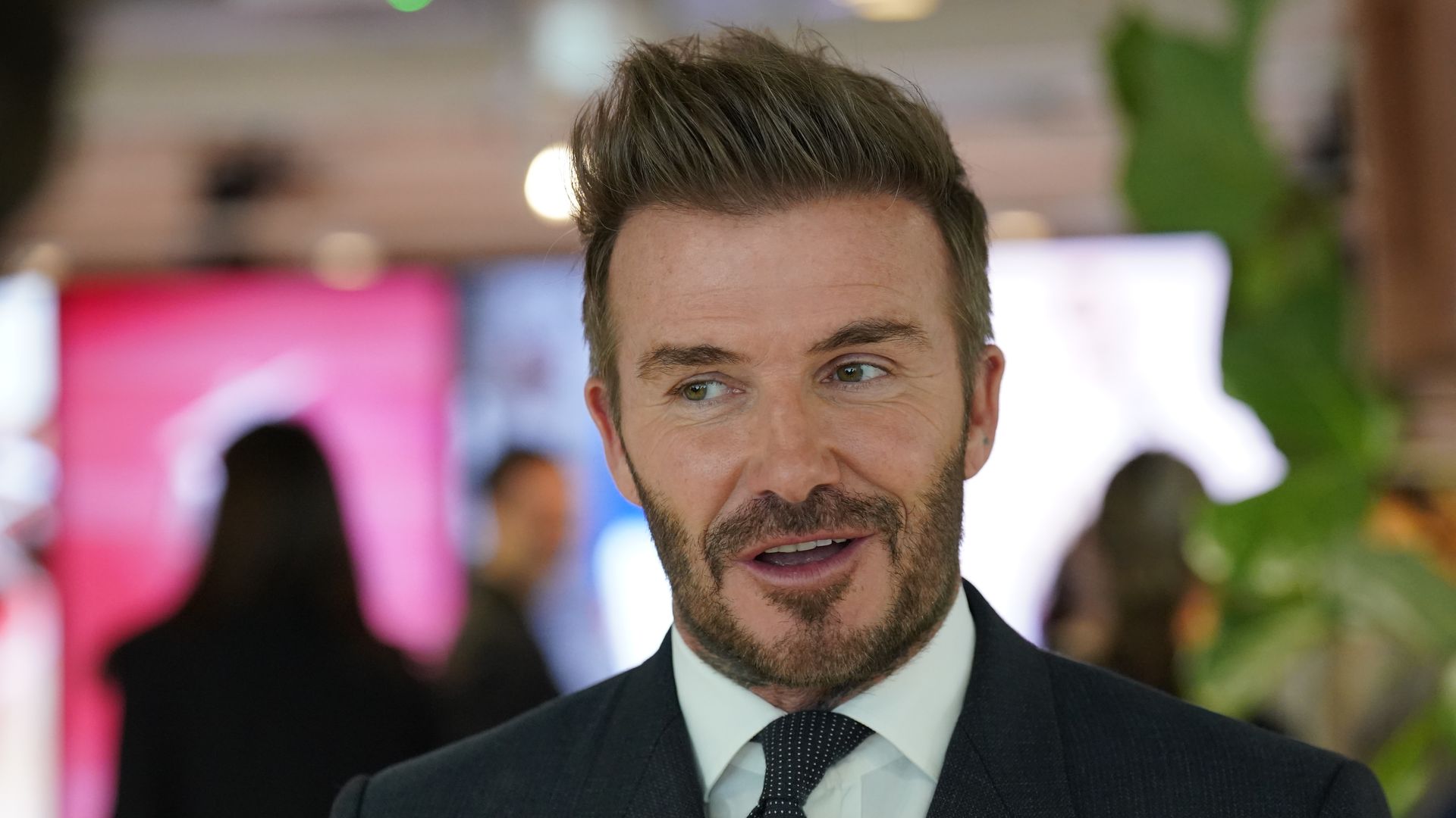 David Beckham looking cheeky in a black suit