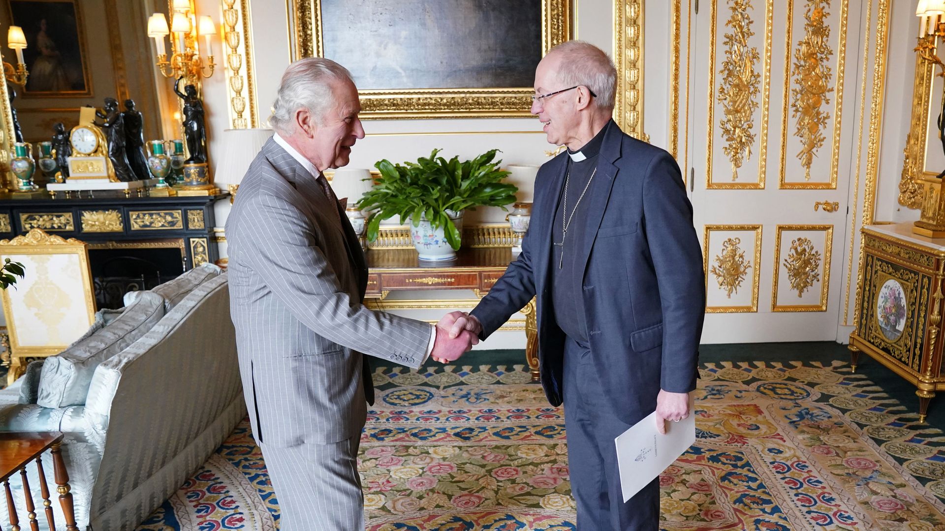 King Charles shaking the hand of the Archbishop of Canterbury inside the White Drawing Room
