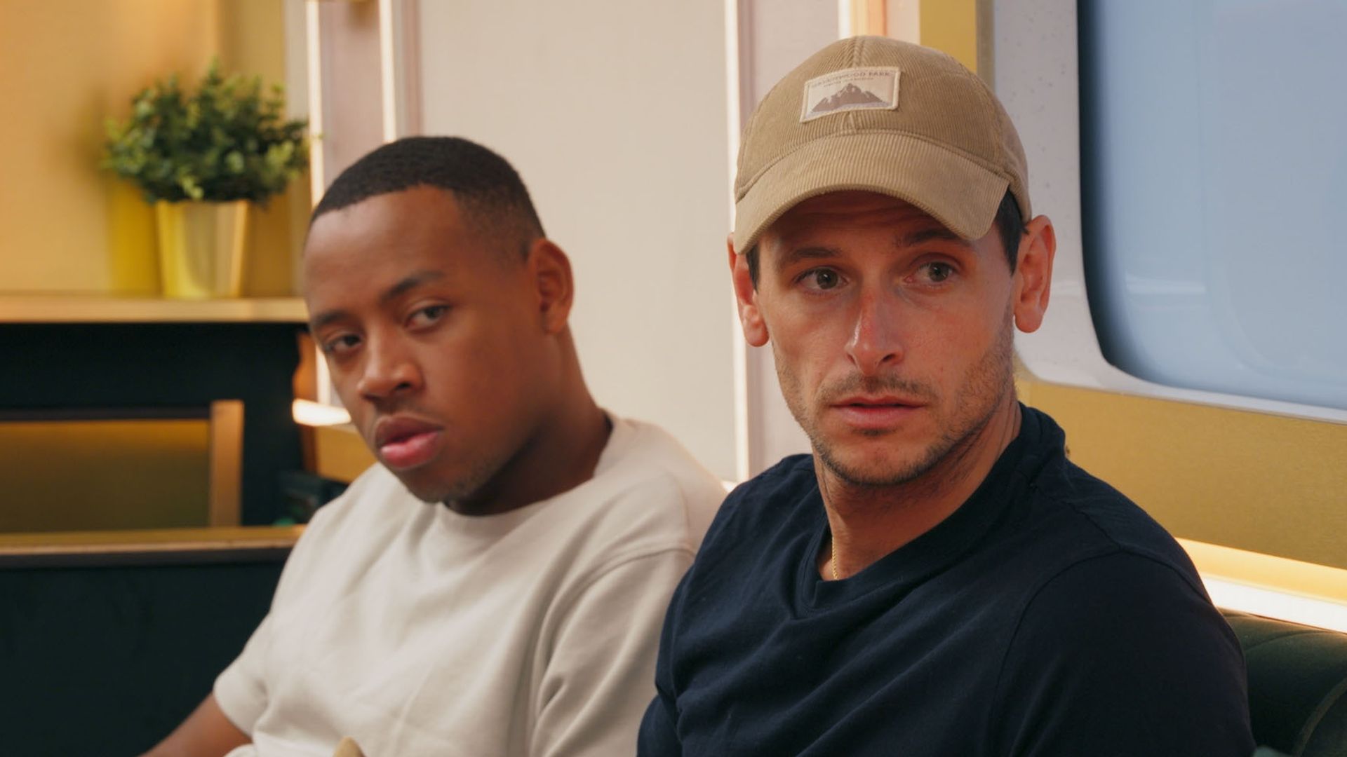 close-up of two men sitting on sofa