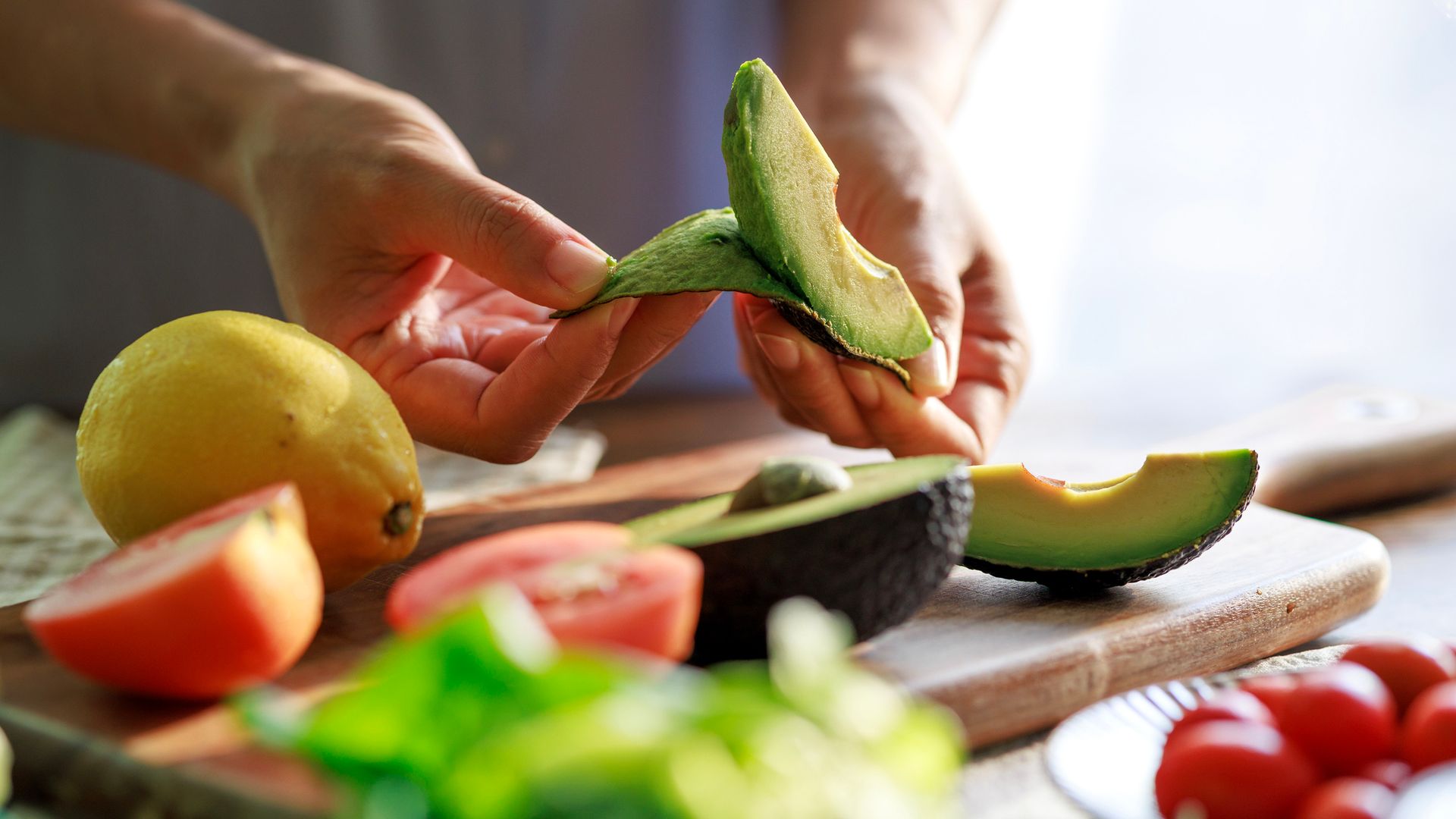 Stock image of man peeling avocado