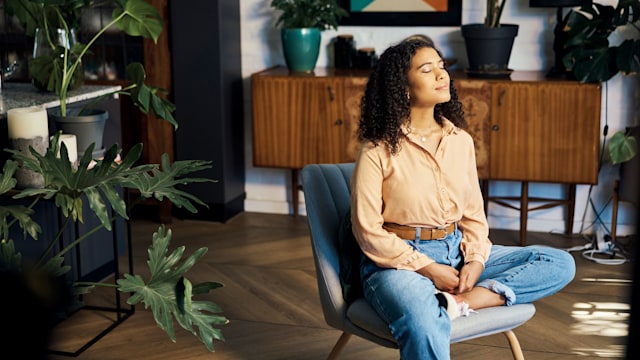 Peace, relax and happy mindset of a woman from Indonesia taking a mind and meditation home break. Happiness of woman on a house living room lounge chair thinking about life, gratitude and self care