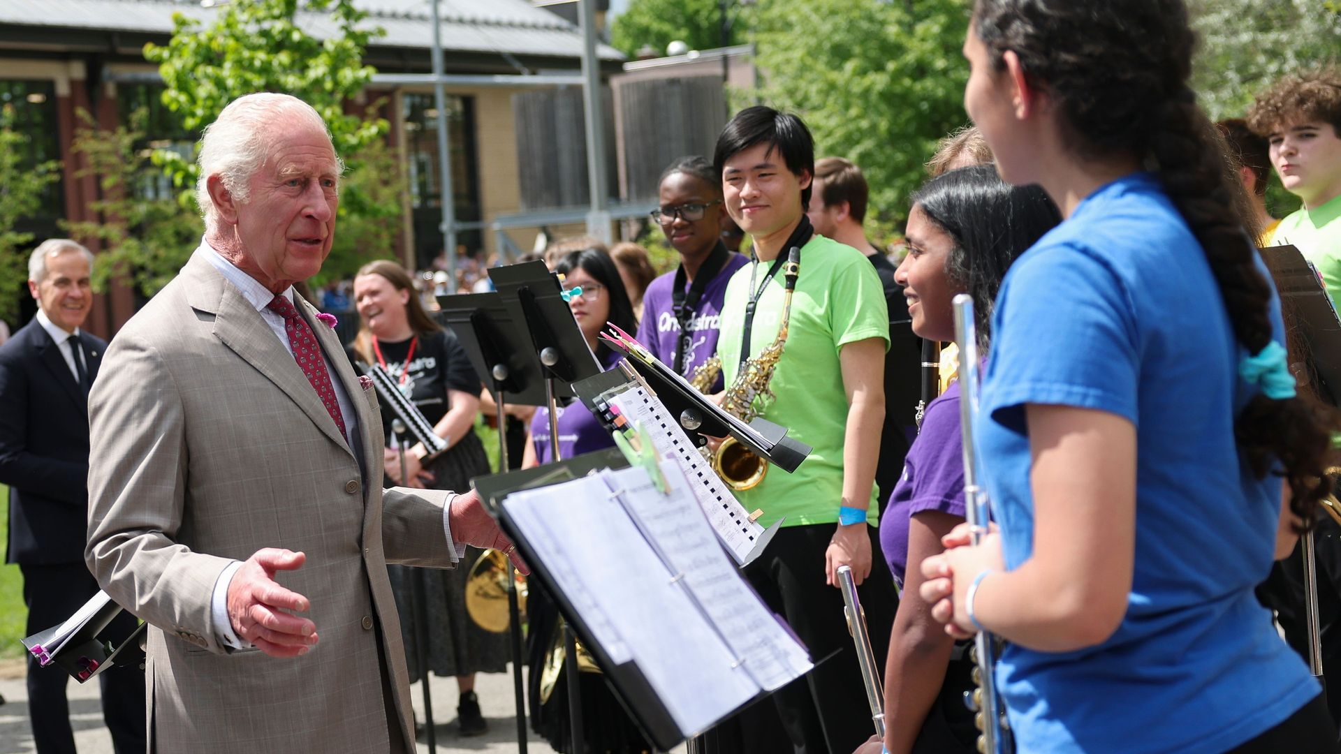 King Charles speaking to music students holding instruments