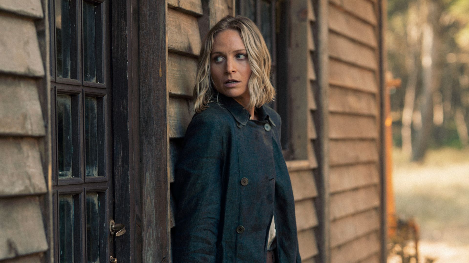 woman standing outside cabin 