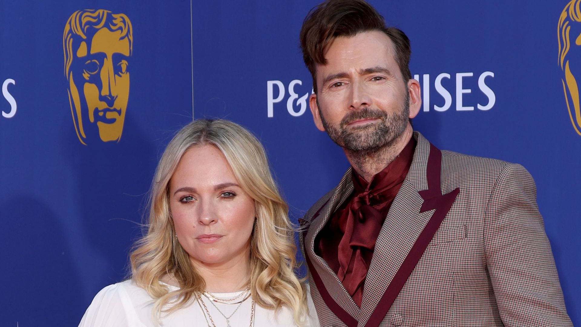 Georgia Tennant in a white dress on the red carpet with David Tennant